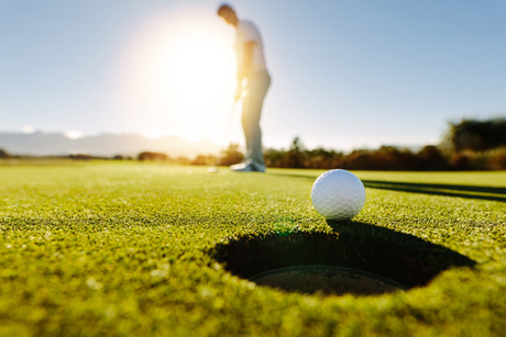Man puts the ball on golf course green Golf, Pickleball & More