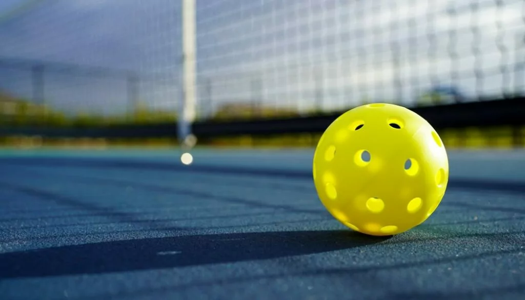 yellow pickleball on court Golf, Pickleball & More