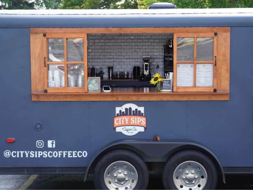 City Sips Coffee Trailer, grey blue with wood trip around the open service window