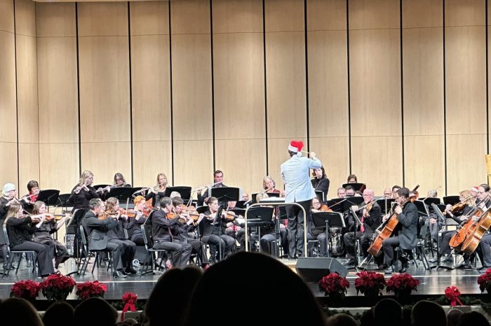 ASO holiday concert from the audience view, conductor in white jacket and santa hat, musicians wearing black