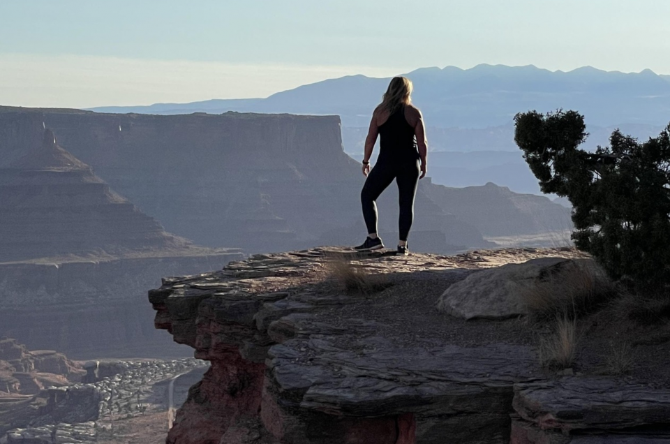 A woman in Athletic wear in the summer standing near what looks like the grand canyon