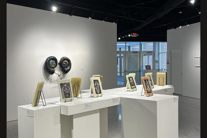 small pieces of art in frames and displayed on easels on white pedestals